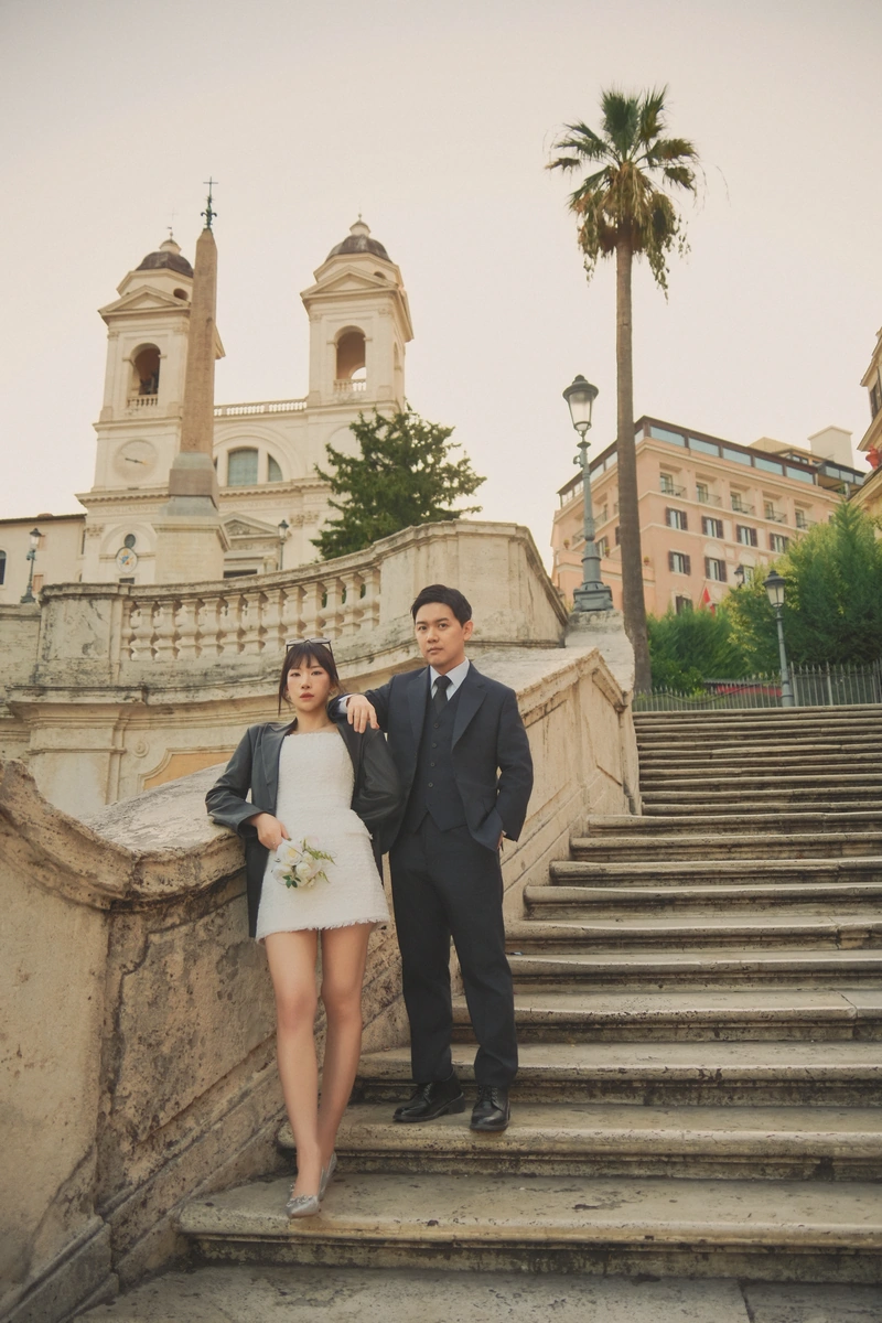 스페인계단과 트리니타 데이 몬티 성당을 배경으로 서 있는 웨딩 커플